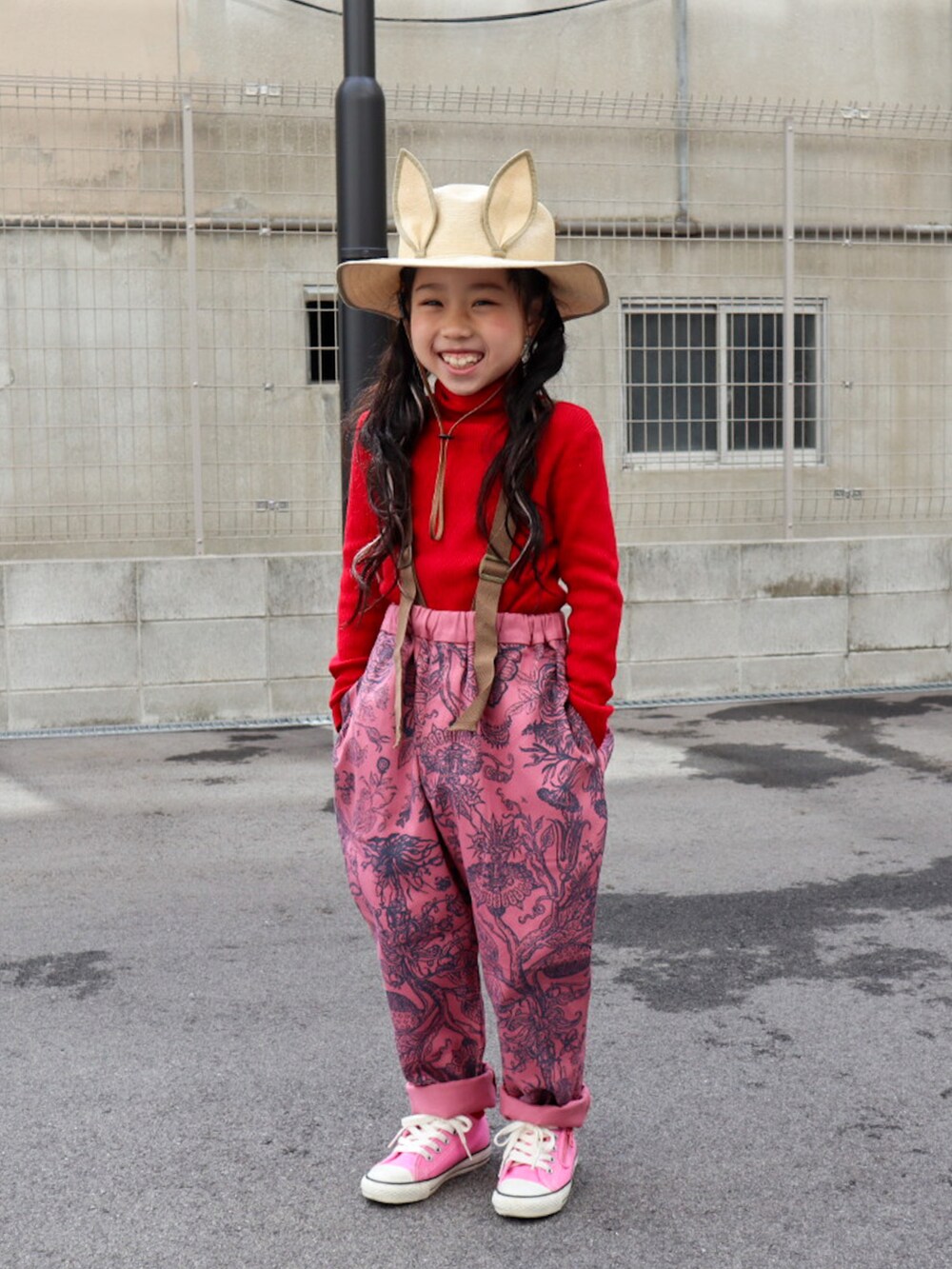 グレー系のMA-1、レッド系のニット/セーター、ピンク系のパンツを着用したキッズの冬コーディネートの4枚目の写真