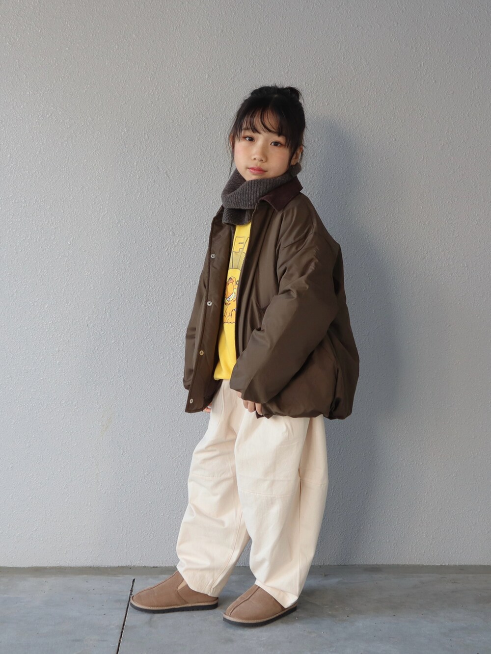 グリーン系のブルゾン、イエロー系のスウェット、ホワイト系のその他パンツを着用したキッズの冬コーディネートの2枚目の写真