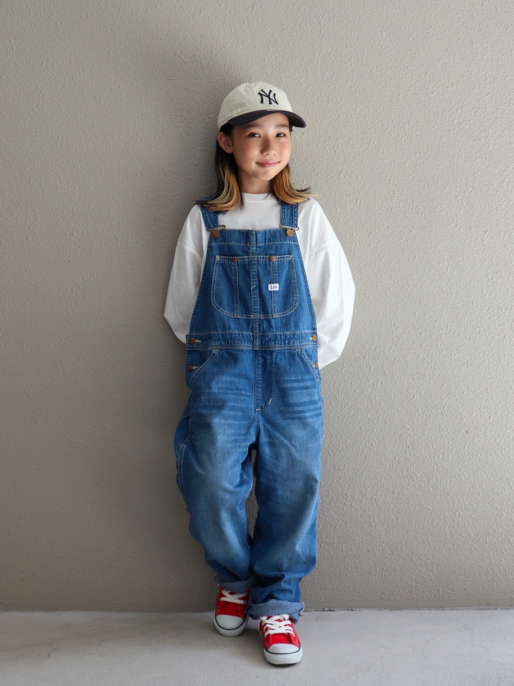ブルー系のサロペット/オーバーオール、レッド系のスニーカー、ホワイト系のTシャツ/カットソーを着用したキッズの秋コーディネートの5枚目の写真