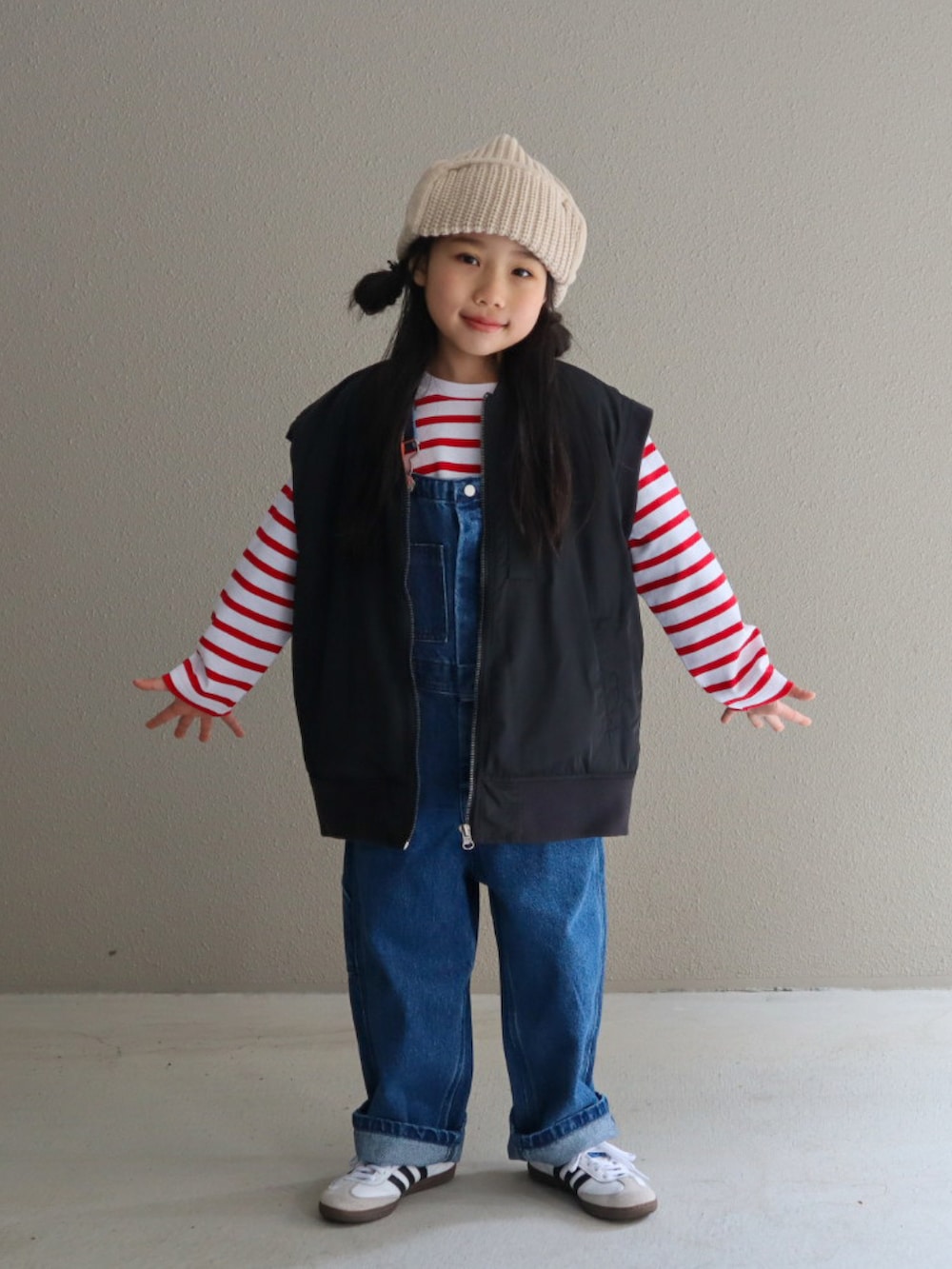 レッド系のTシャツ/カットソー、ブルー系のサロペット/オーバーオール、ブラック系のMA-1を着用したキッズの冬コーディネートの3枚目の写真