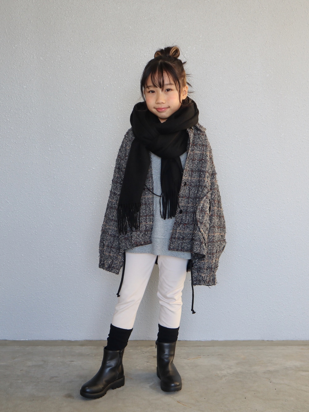 グレー系のスウェット、ブラック系のブーツ、ブラック系のマフラーを着用したキッズの冬コーディネートの3枚目の写真