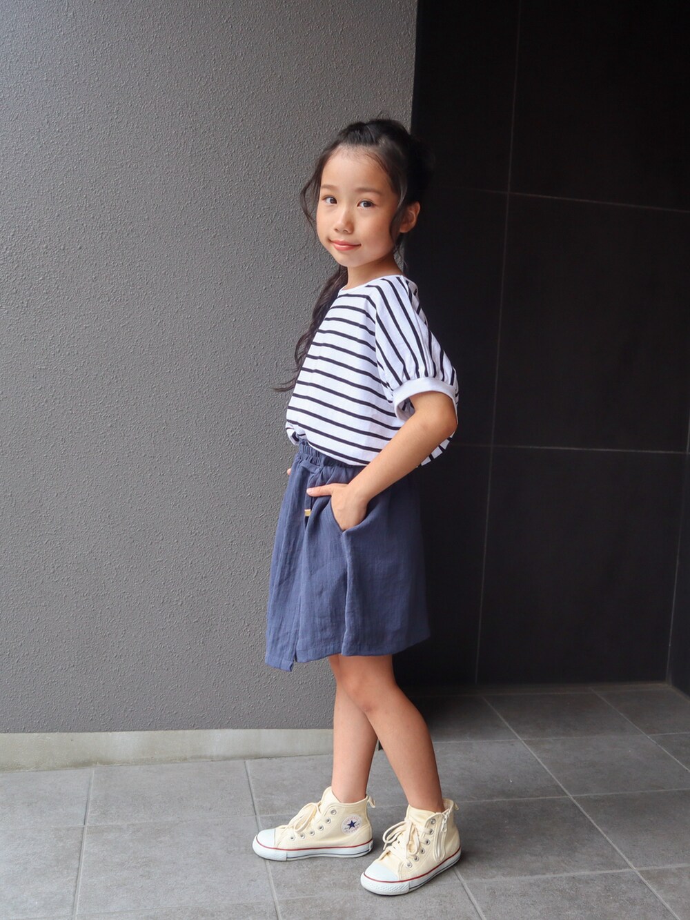 ホワイト系のTシャツ/カットソー、ブルー系のスカート、ホワイト系のスニーカーを着用したキッズの夏コーディネートの3枚目の写真