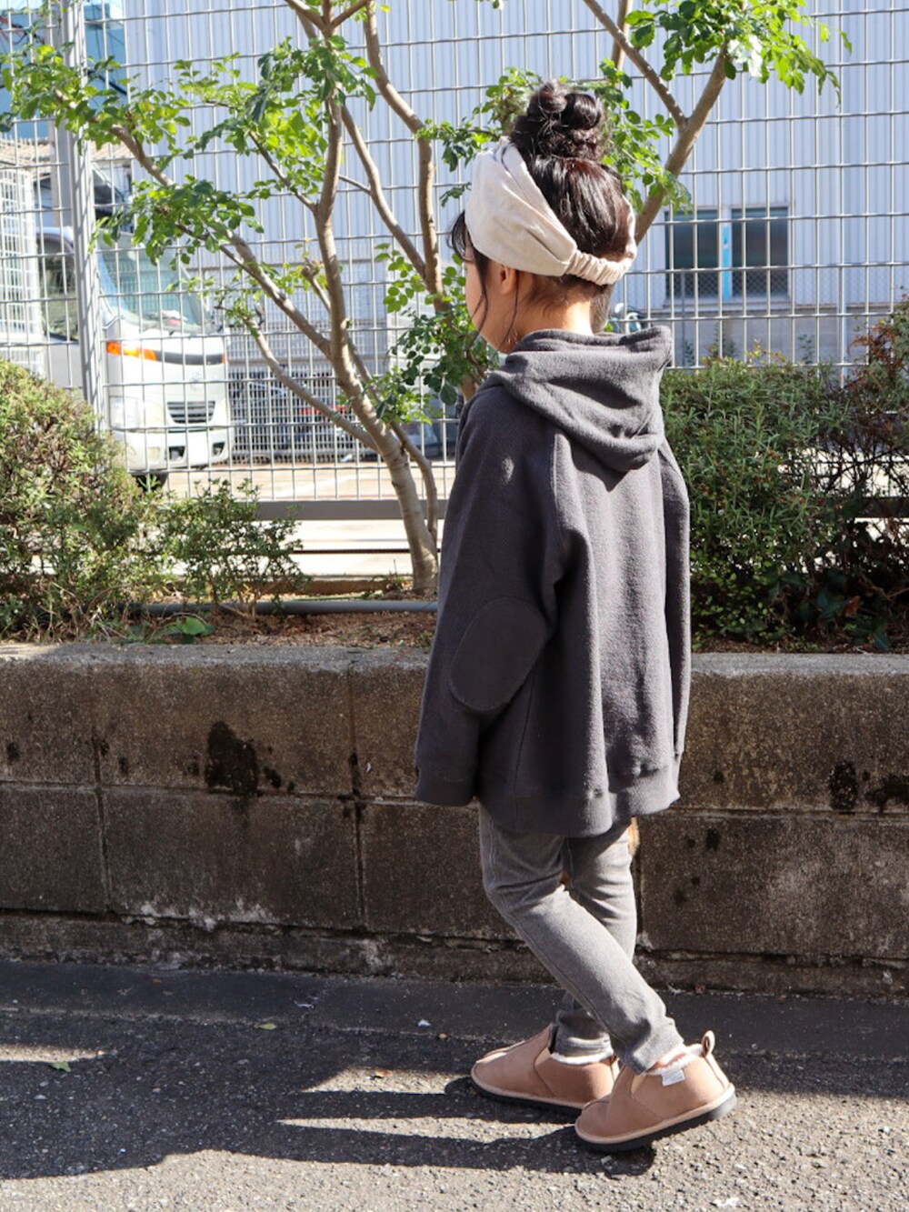 ブラック系のパーカー、ブラック系のデニムパンツ、ベージュ系のブーツを着用したキッズの秋コーディネートの3枚目の写真