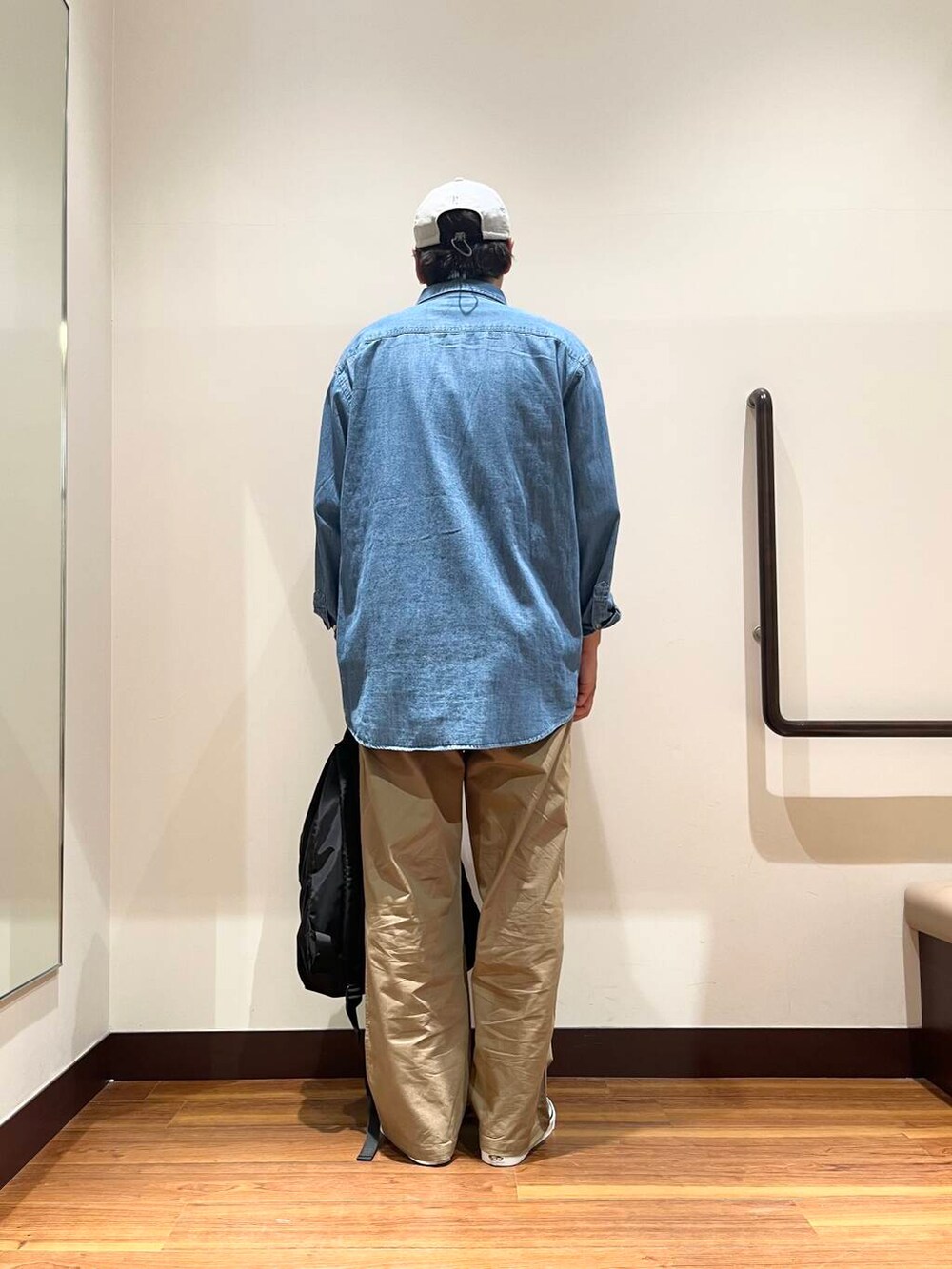 ブラック系のバックパック/リュック、グレー系のTシャツ/カットソー、グリーン系のチノパンツを着用したメンズの夏コーディネートの2枚目の写真