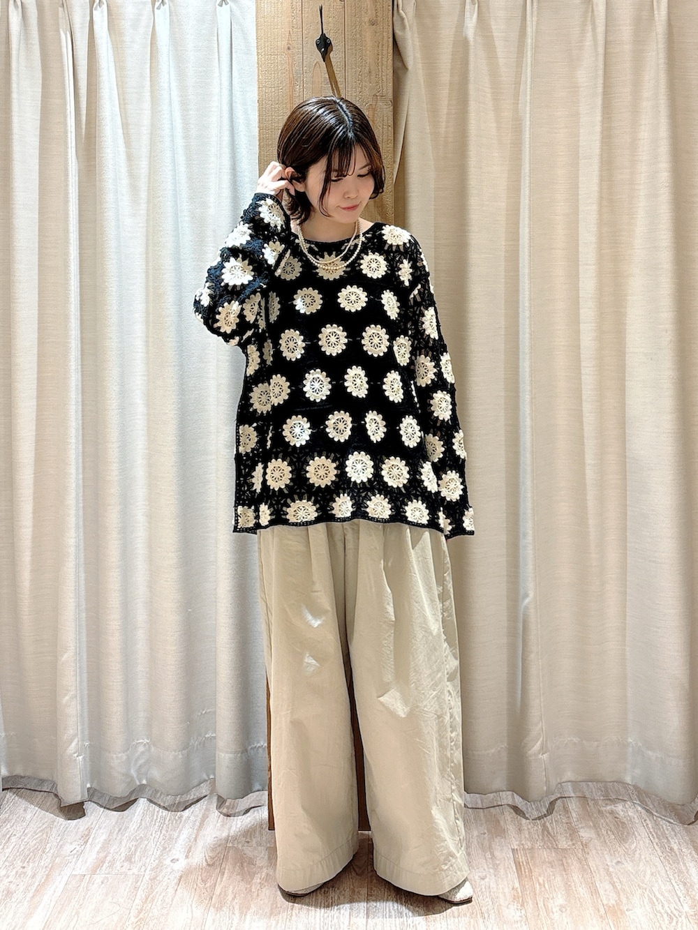 ベージュ系のその他パンツ、グリーン系のニット/セーター、ブラック系のキャミソールを着用したレディースの春コーディネートの4枚目の写真