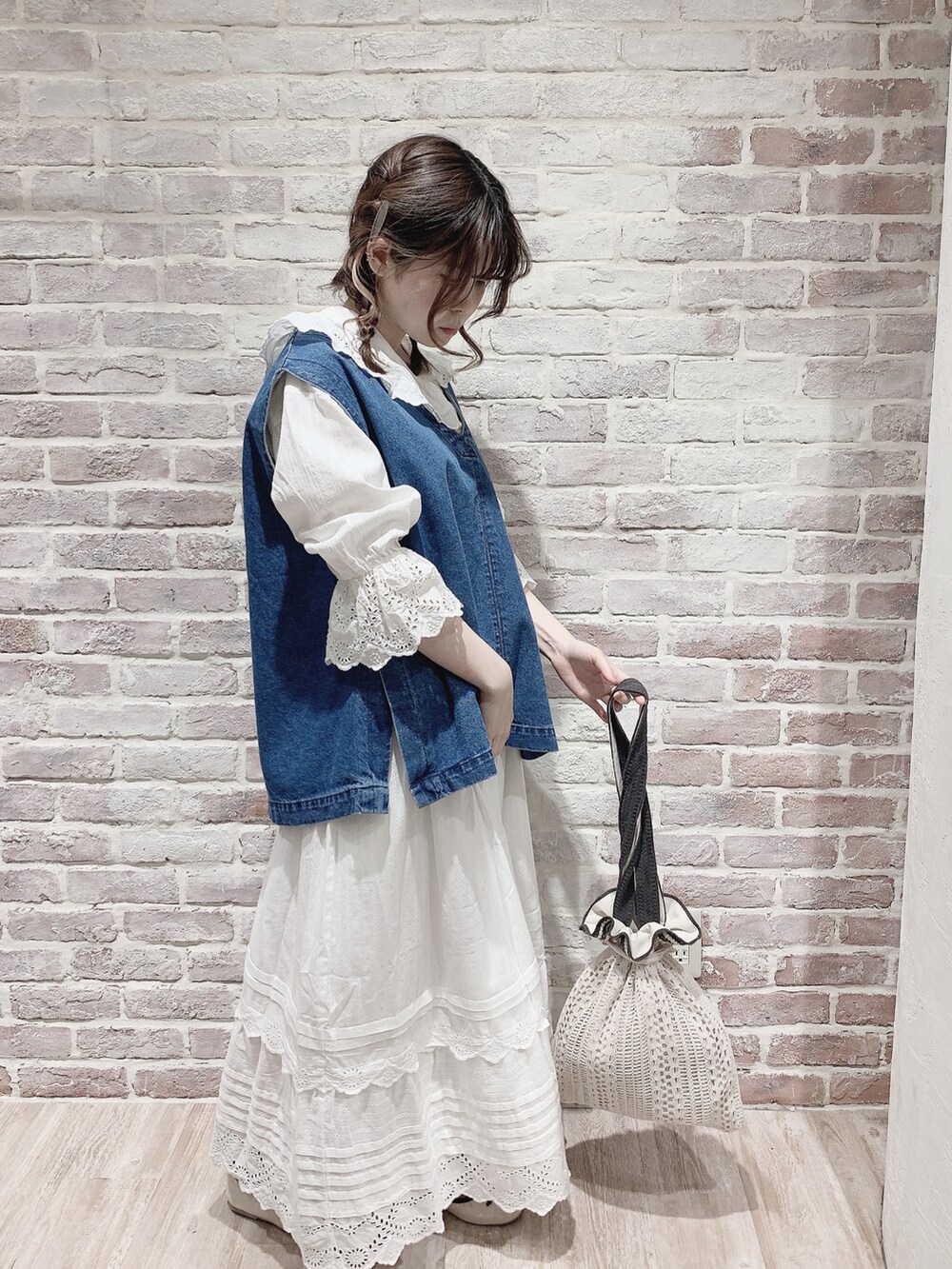 ブルー系のベスト、ホワイト系のシャツ/ブラウス、ホワイト系のスカートを着用したレディースの春コーディネートの3枚目の写真