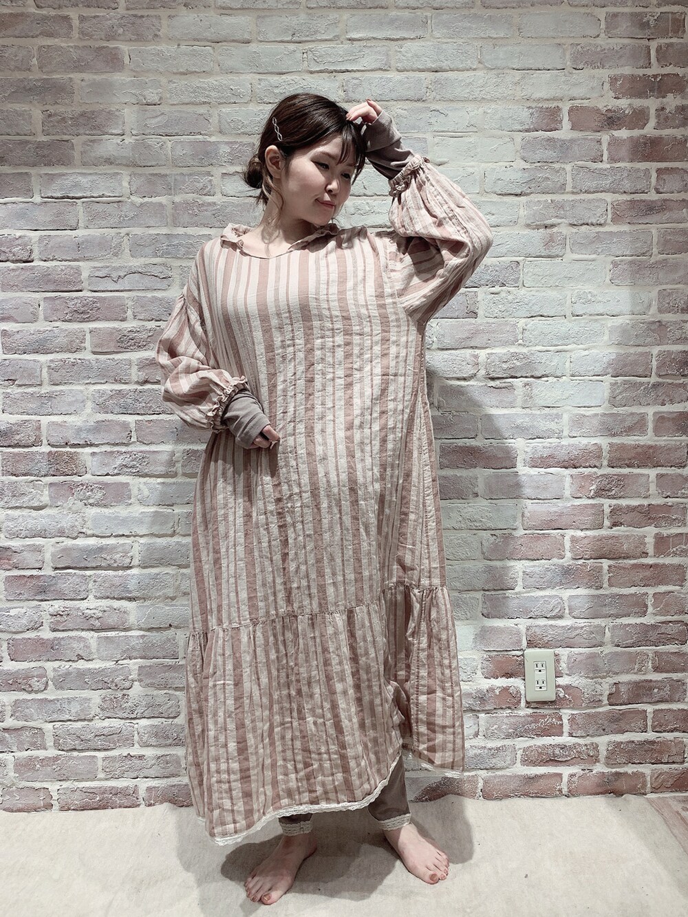 オレンジ系のワンピース/ドレス、ブラウン系のTシャツ/カットソー、ブラウン系のレギンス/スパッツを着用したレディースの秋コーディネートの2枚目の写真