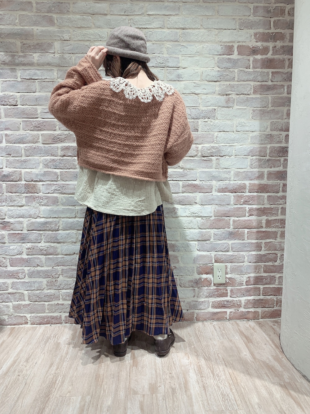 オレンジ系のニット/セーター、ベージュ系のシャツ/ブラウス、ブルー系のスカートを着用したレディースの秋コーディネートの4枚目の写真
