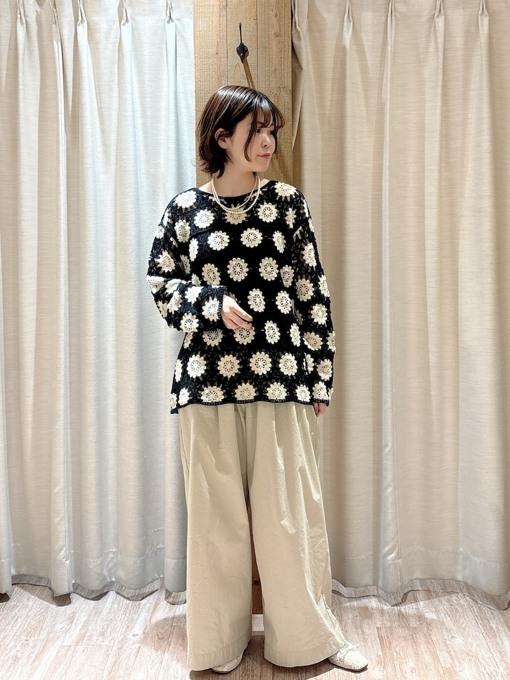 ベージュ系のその他パンツ、グリーン系のニット/セーター、ブラック系のキャミソールを着用したレディースの春コーディネートの3枚目の写真