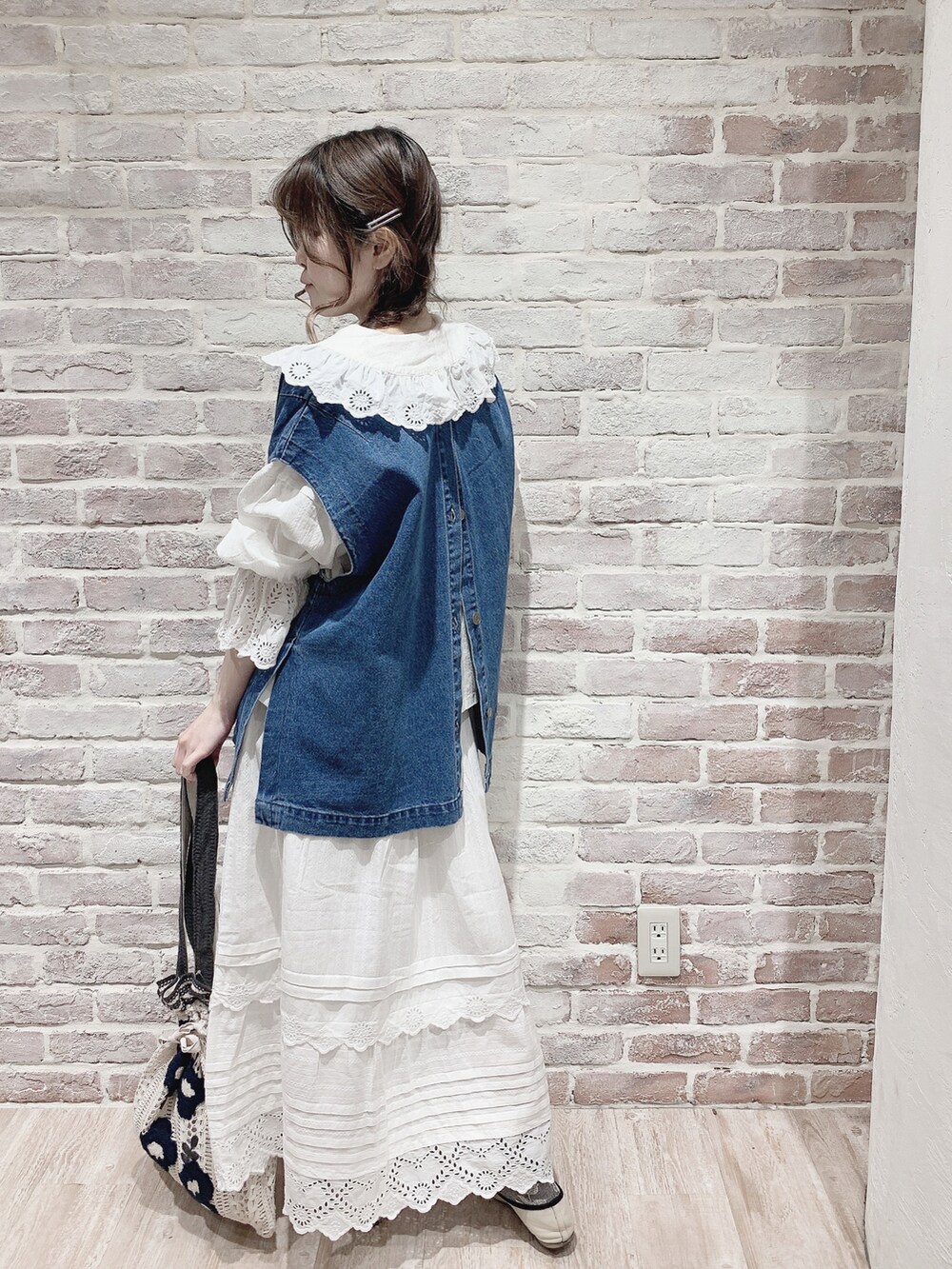 ブルー系のベスト、ホワイト系のシャツ/ブラウス、ホワイト系のスカートを着用したレディースの春コーディネートの2枚目の写真