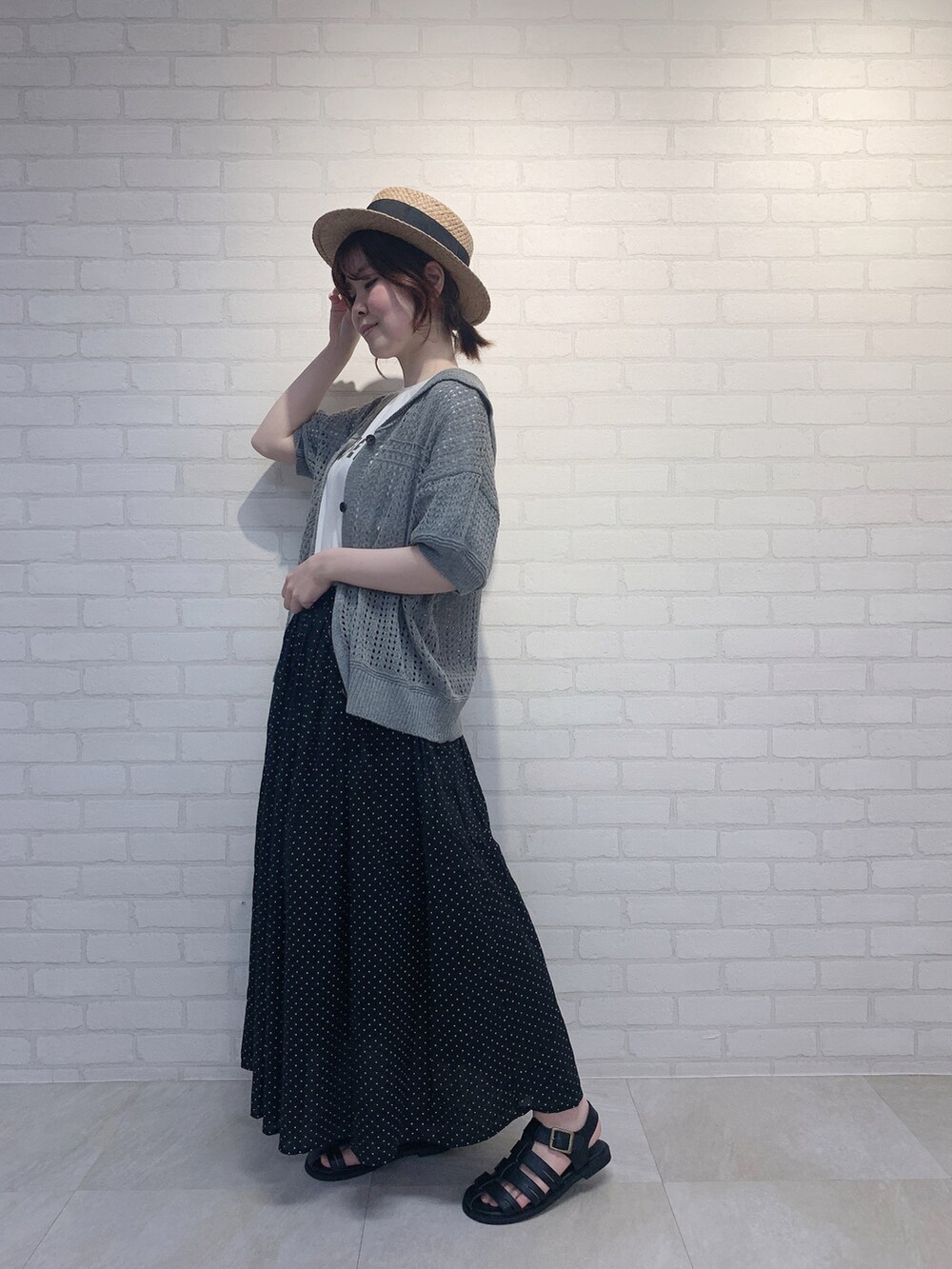 ブラック系のスカート、グレー系のニット/セーター、ホワイト系のTシャツ/カットソーを着用したレディースの春コーディネートの3枚目の写真