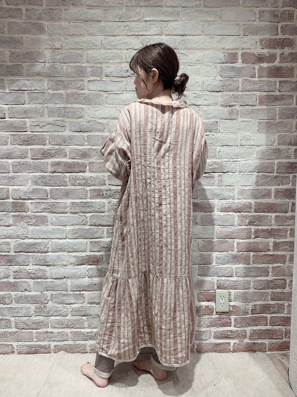 オレンジ系のワンピース/ドレス、ブラウン系のTシャツ/カットソー、ブラウン系のレギンス/スパッツを着用したレディースの秋コーディネートの4枚目の写真