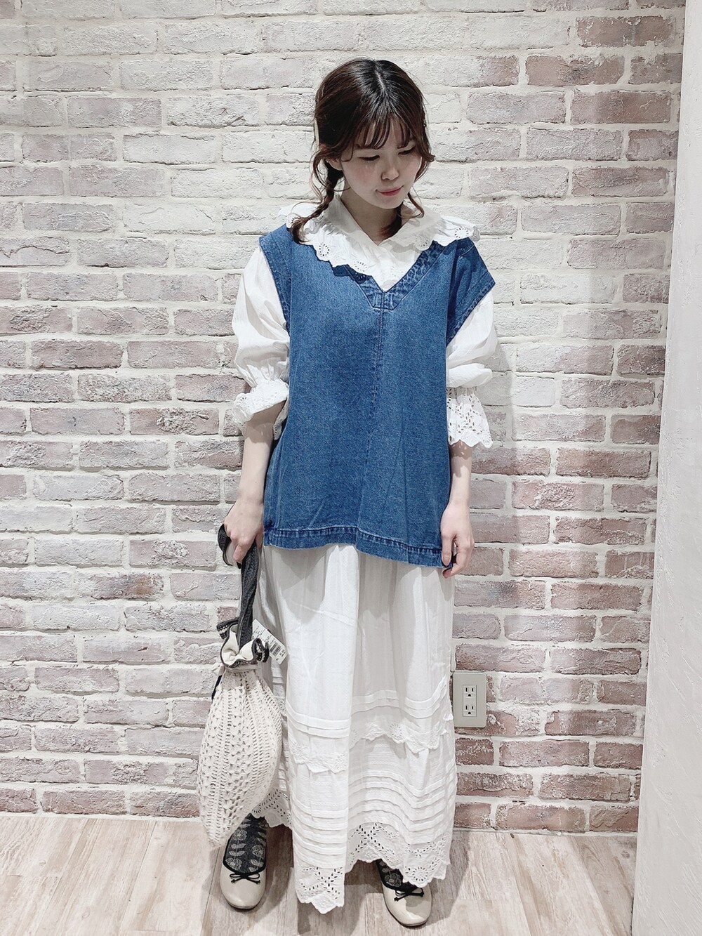 ブルー系のベスト、ホワイト系のシャツ/ブラウス、ホワイト系のスカートを着用したレディースの春コーディネートの4枚目の写真