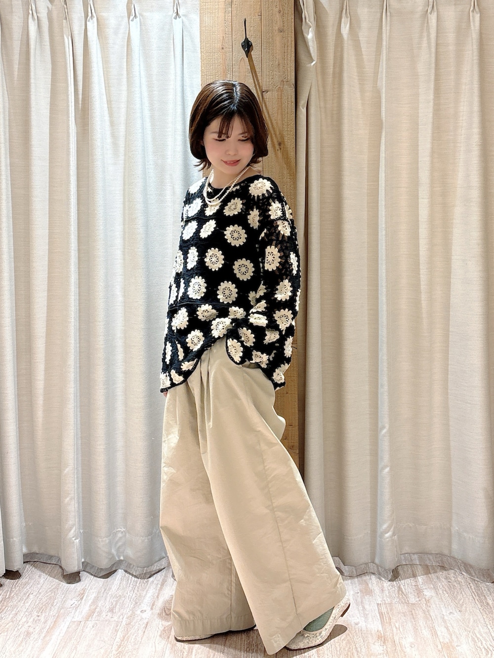 ベージュ系のその他パンツ、グリーン系のニット/セーター、ブラック系のキャミソールを着用したレディースの春コーディネートの2枚目の写真