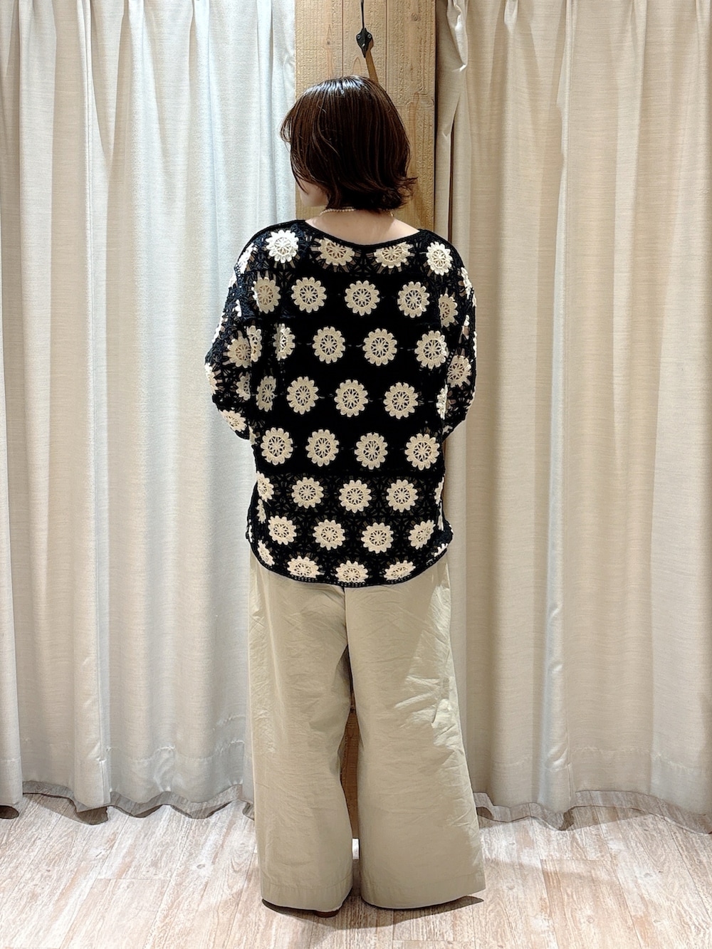 ベージュ系のその他パンツ、グリーン系のニット/セーター、ブラック系のキャミソールを着用したレディースの春コーディネートの5枚目の写真