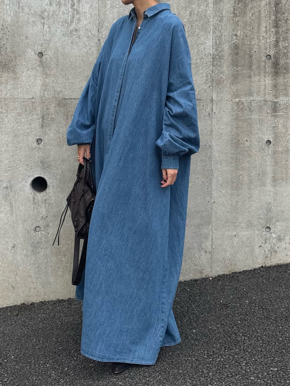 ブルー系のシャツワンピース、ブラウン系のバッグを着用したレディースの春コーディネートの2枚目の写真