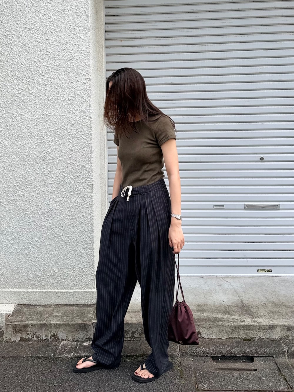 ブラック系のその他パンツ、グリーン系のTシャツ/カットソーを着用したレディースの夏コーディネートの2枚目の写真