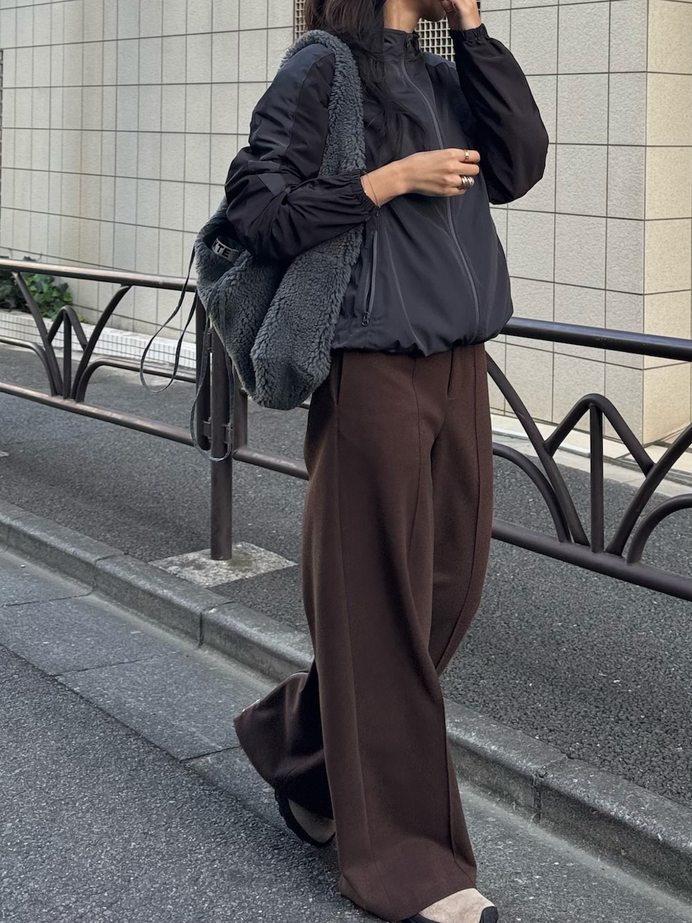 グレー系のトートバッグ、ブラック系のその他パンツ、ベージュ系のシューズを着用したレディースの秋コーディネートの3枚目の写真