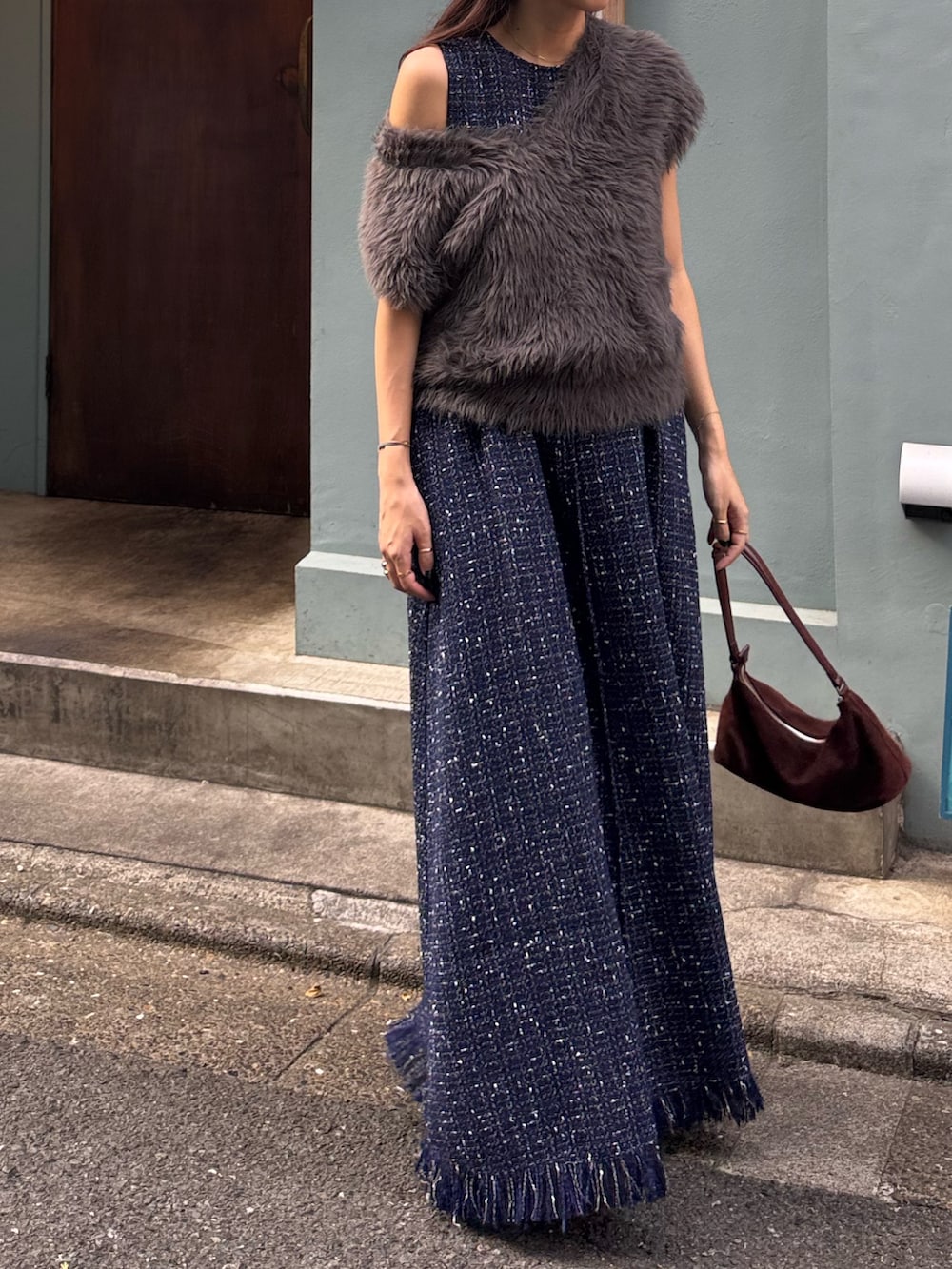 グレー系のベスト、ブルー系のワンピースを着用したレディースの秋コーディネートの2枚目の写真