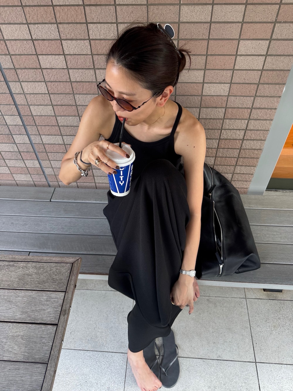 ブラック系のワンピースを着用したレディースの夏コーディネートの2枚目の写真