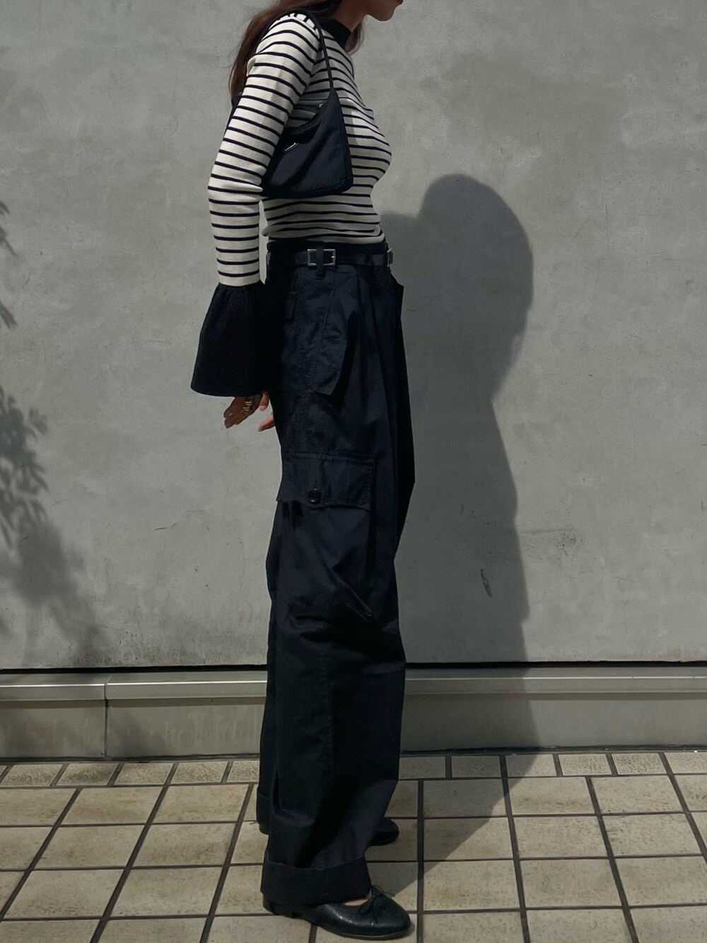 ホワイト系のニット/セーター、ブラック系のバッグ、ブルー系のパンツを着用したレディースの秋コーディネートの2枚目の写真