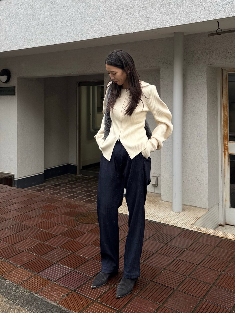 ブルー系のパンツ、ホワイト系のニット/セーター、ブラック系のシューズを着用したレディースの冬コーディネートの3枚目の写真