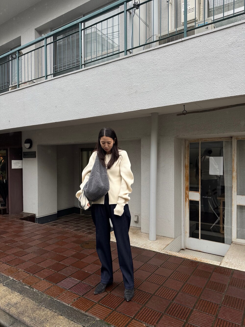 ブルー系のパンツ、ホワイト系のニット/セーター、ブラック系のシューズを着用したレディースの冬コーディネートの2枚目の写真