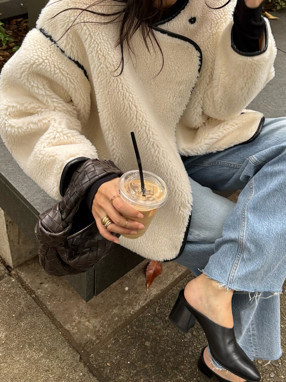 ホワイト系のブルゾン、ブラウン系のバッグ、ブルー系のパンツを着用したレディースの秋コーディネートの3枚目の写真