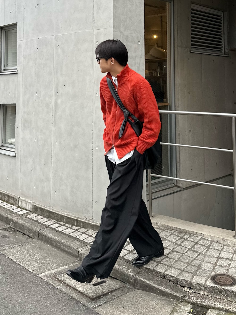 オレンジ系のブルゾン、ブラック系のスラックス、ホワイト系のシャツ/ブラウスを着用したメンズの冬コーディネートの3枚目の写真