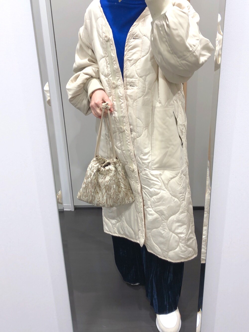 ブルー系のニット/セーター、ブルー系のスカート、ホワイト系のその他アウターを着用したレディースの冬コーディネートの2枚目の写真