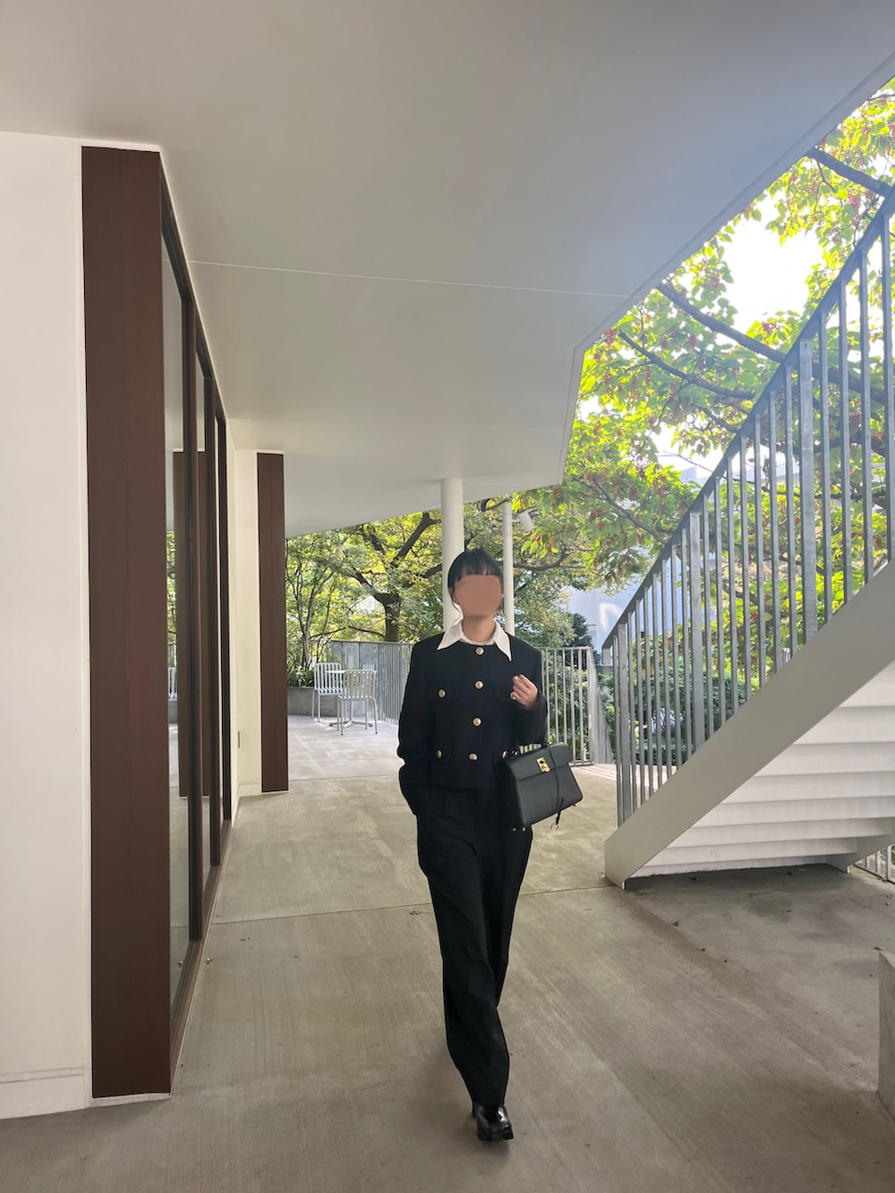 ブラック系のノーカラージャケット、ブラック系のハンドバッグ、ブラック系のブーツを着用したレディースの冬コーディネートの3枚目の写真