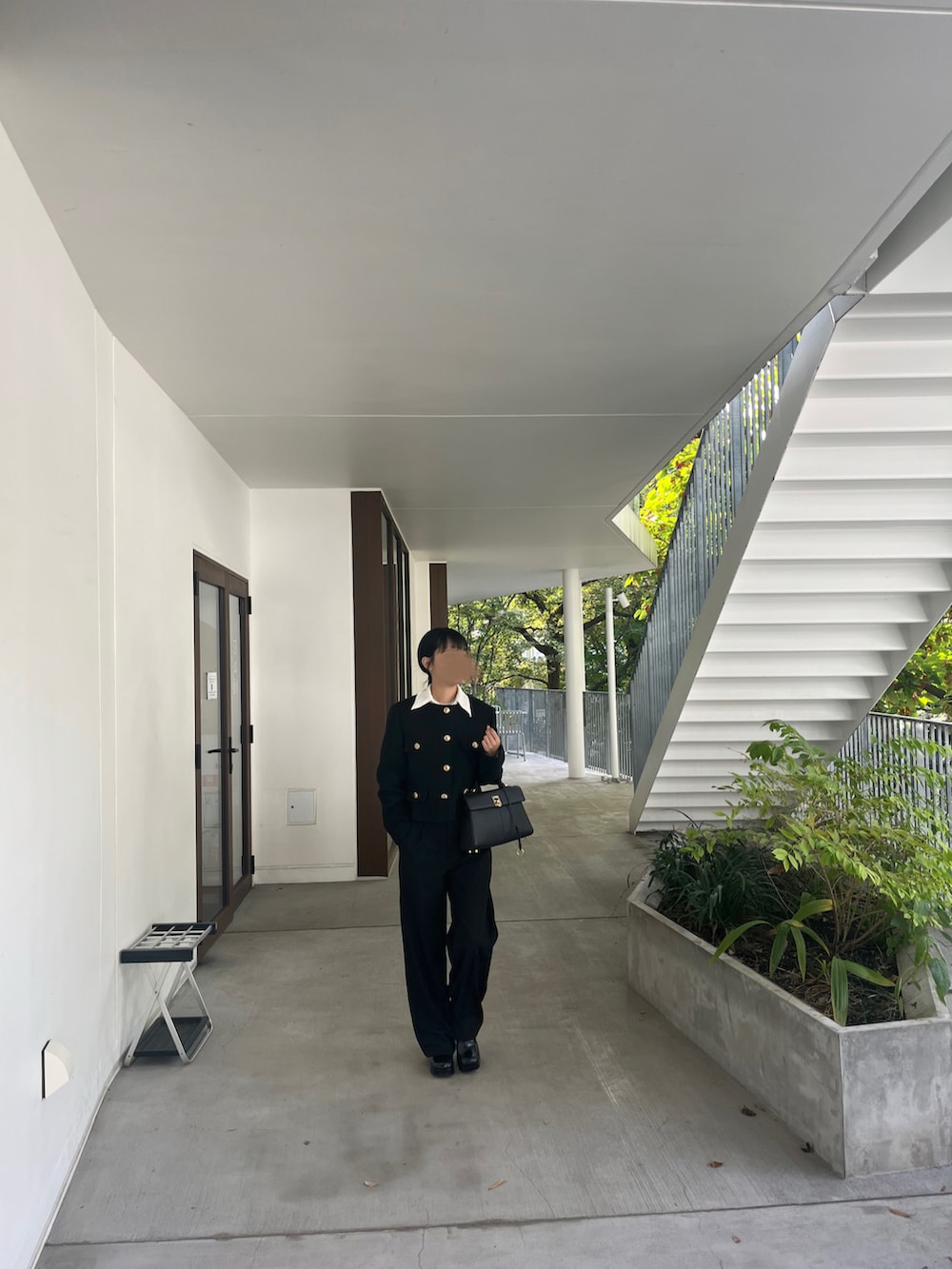 ブラック系のノーカラージャケット、ブラック系のハンドバッグ、ブラック系のブーツを着用したレディースの冬コーディネートの4枚目の写真