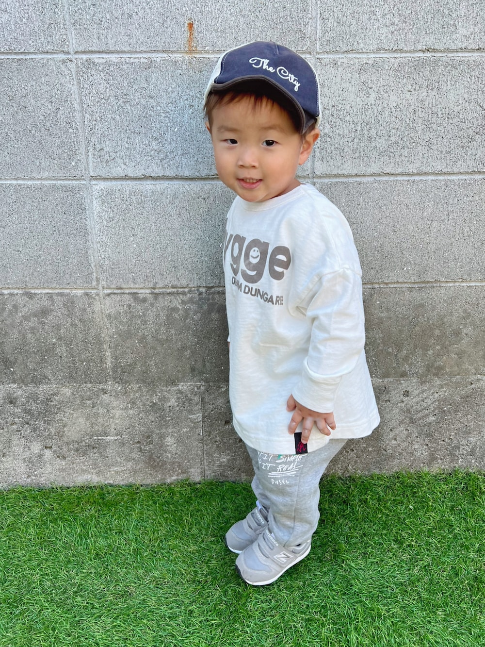 ホワイト系のTシャツ/カットソー、グレー系のスニーカー、ブルー系のキャップを着用したキッズの秋コーディネートの2枚目の写真