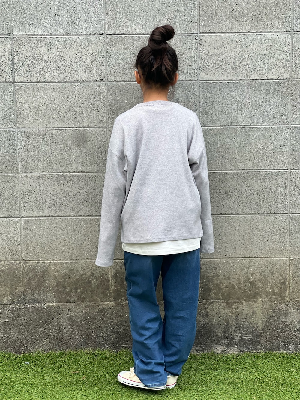 ホワイト系のスニーカー、ブラウン系のサングラスを着用したキッズの冬コーディネートの2枚目の写真