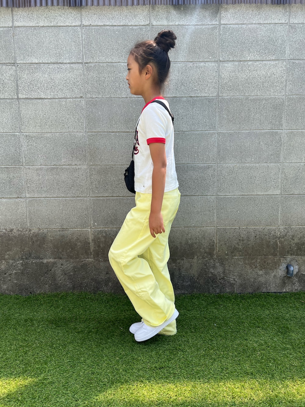 イエロー系のデニムパンツ、ホワイト系のスニーカーを着用したキッズの春コーディネートの2枚目の写真