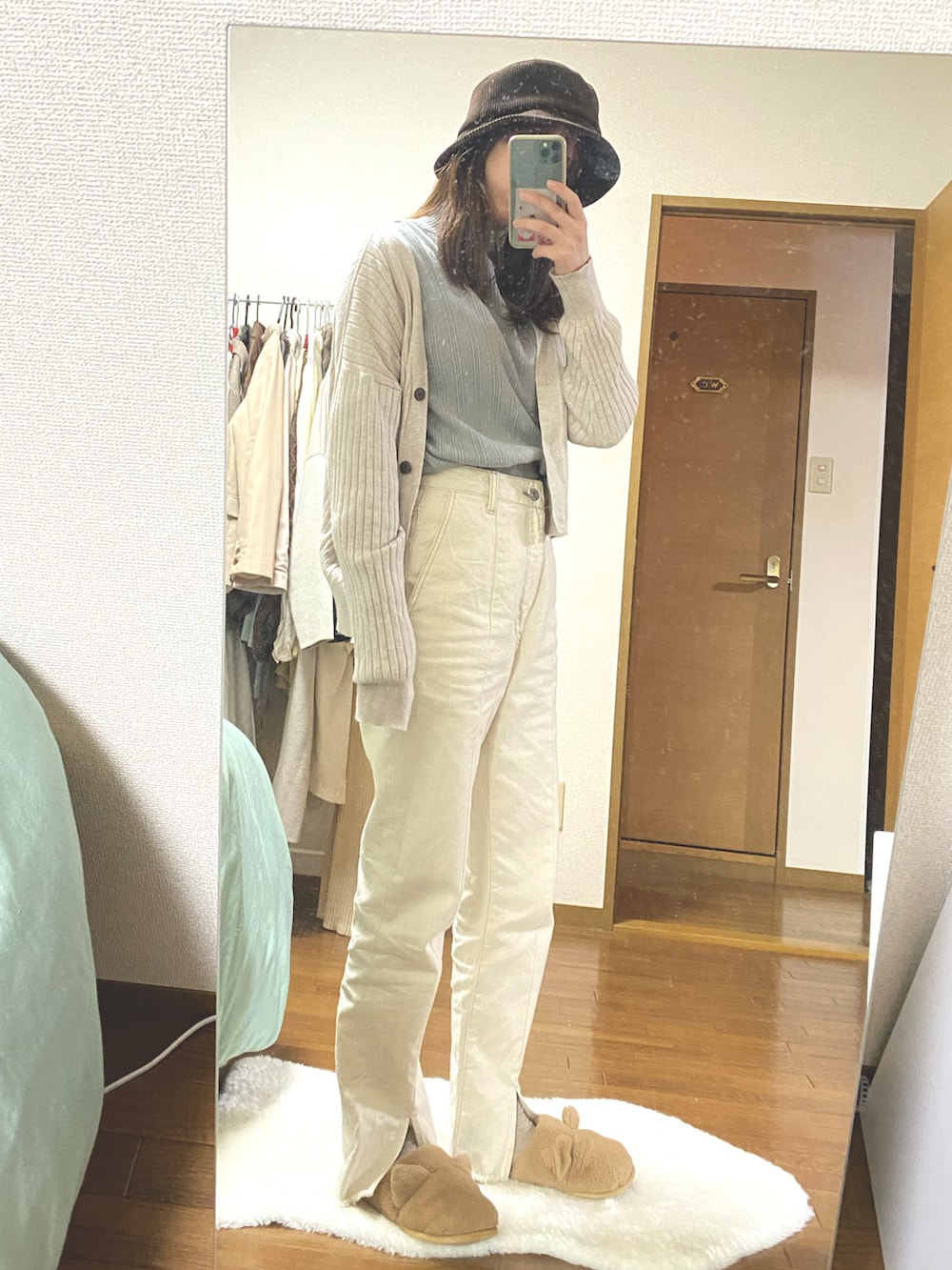 ホワイト系のデニムパンツ、ブルー系のカーディガン/ボレロ、ブルー系のニット/セーターを着用したレディースの春コーディネートの2枚目の写真