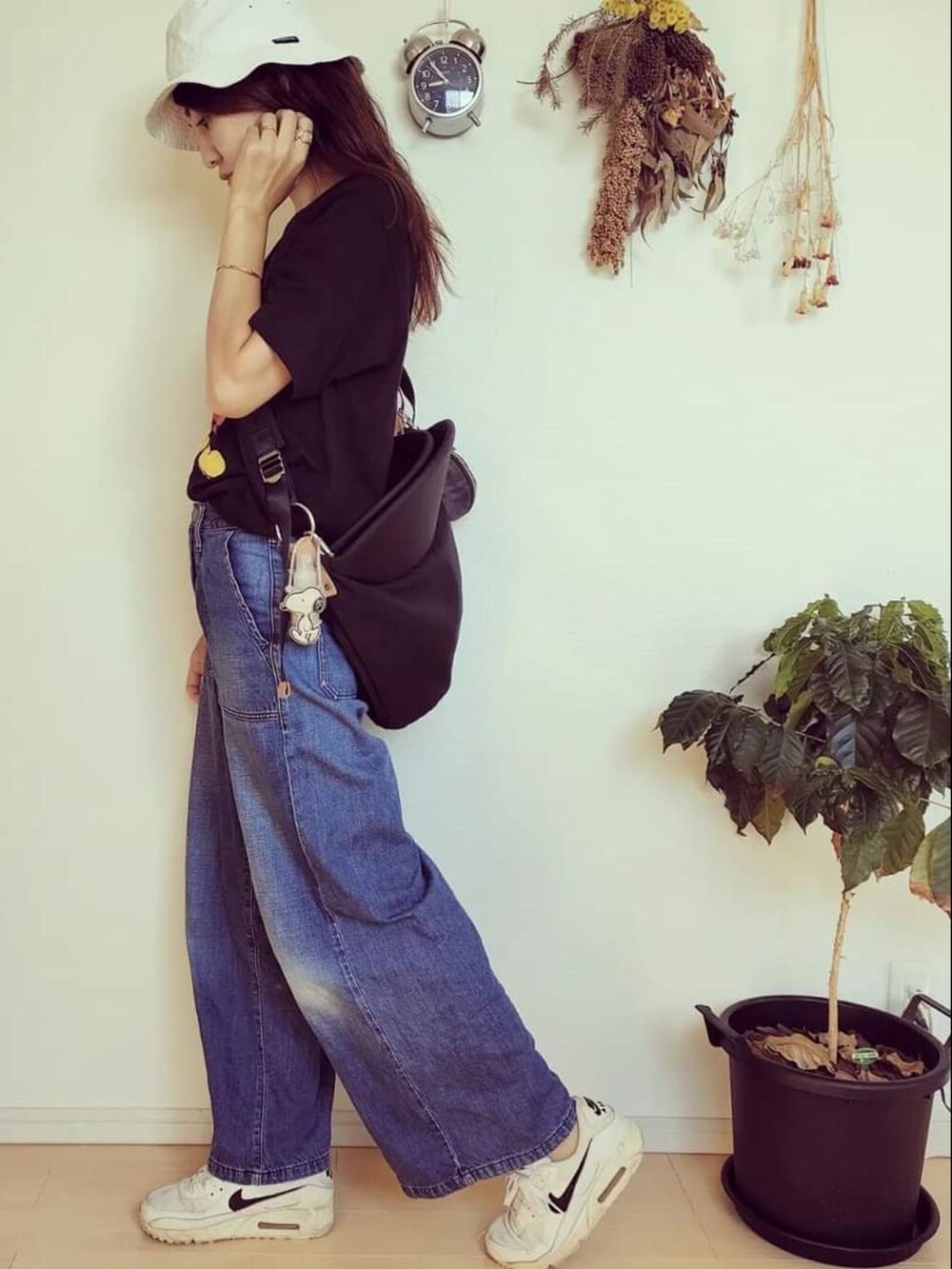 ブラック系のTシャツ/カットソー、ブルー系のデニムパンツ、ブラック系のバッグを着用したレディースの秋コーディネートの3枚目の写真