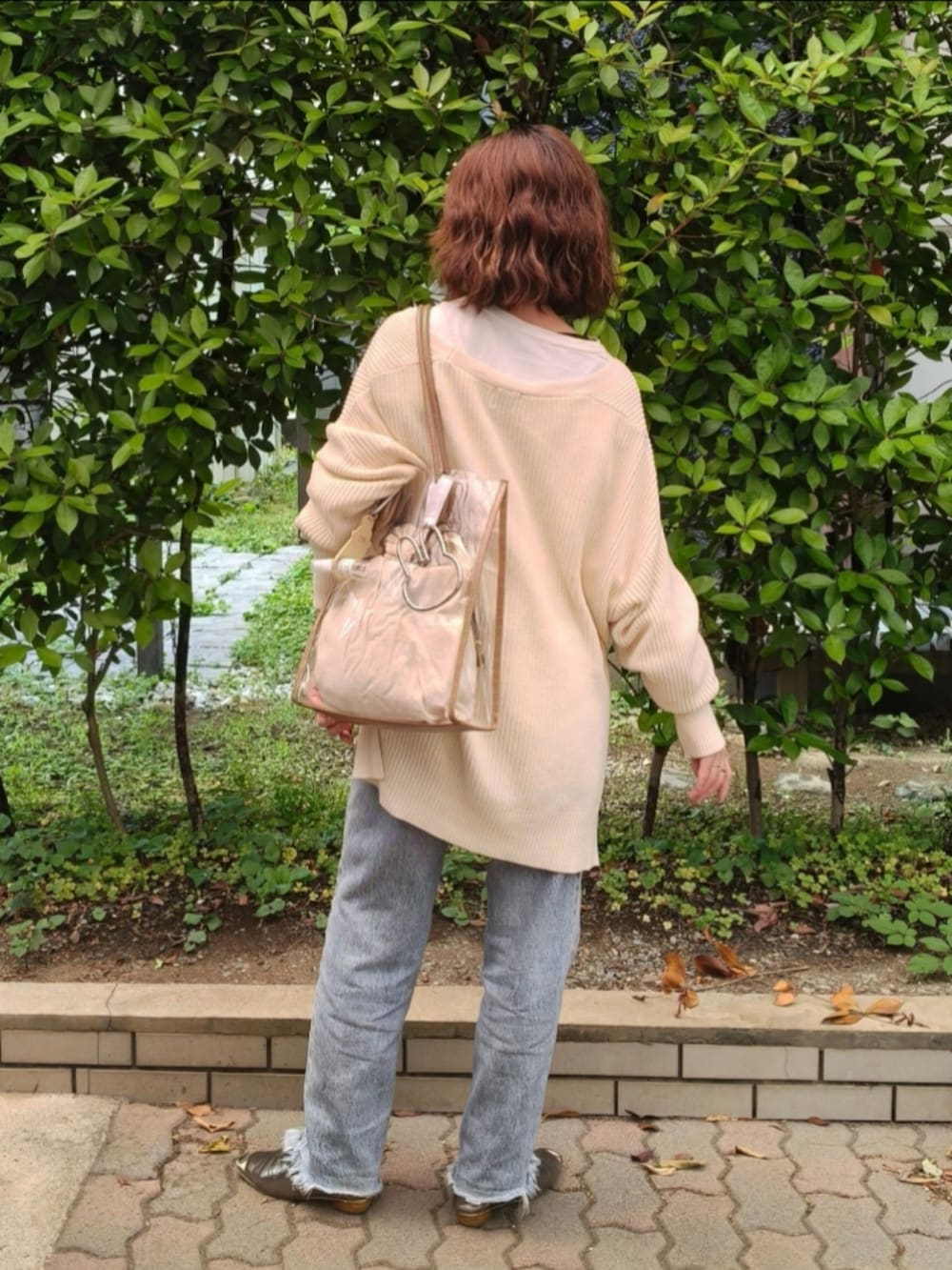 ホワイト系のカーディガン/ボレロ、ブルー系のデニムパンツ、ゴールド系のパンプスを着用したレディースの秋コーディネートの3枚目の写真