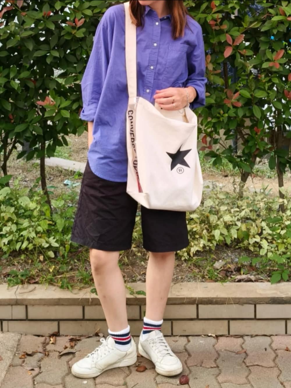 ブルー系のシャツ/ブラウス、ホワイト系のスニーカー、ホワイト系のトートバッグを着用したレディースの秋コーディネートの2枚目の写真