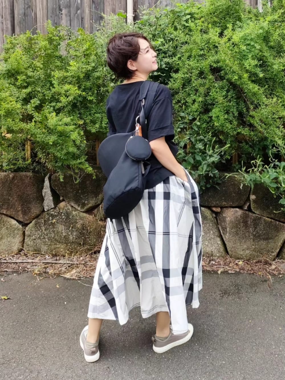 ブラック系のTシャツ/カットソー、ブラック系のバッグ、ブラウン系のスニーカーを着用したレディースの秋コーディネートの2枚目の写真