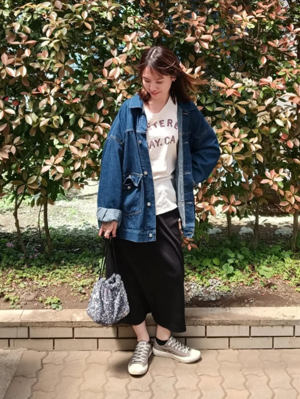 イエロー系のTシャツ/カットソー、ブルー系のデニムジャケット、シルバー系のショルダーバッグを着用したレディースの春コーディネートの2枚目の写真