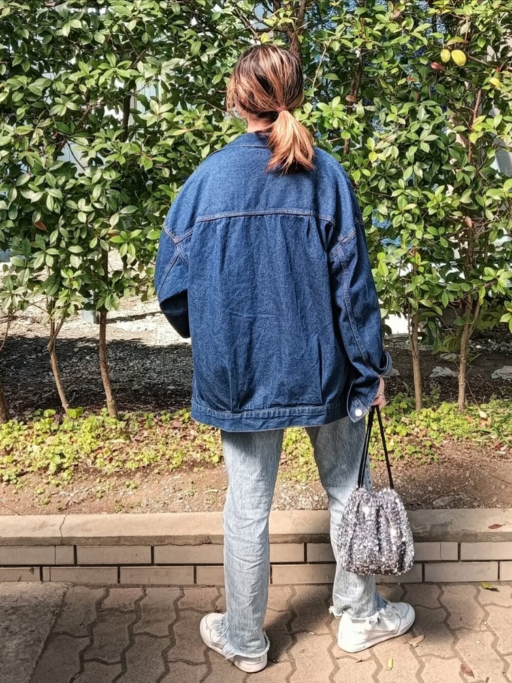 イエロー系のTシャツ/カットソー、グリーン系のカーディガン/ボレロ、ブルー系のデニムジャケットを着用したレディースの春コーディネートの3枚目の写真