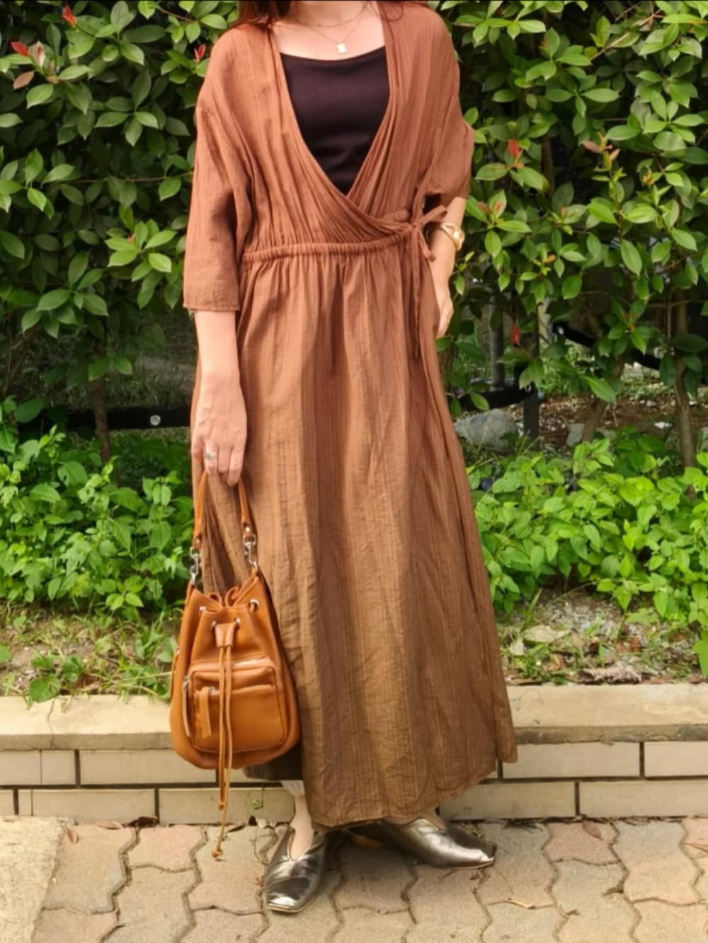 ブラック系のキャミソール、グリーン系のワンピース、ブラウン系のショルダーバッグを着用したレディースの秋コーディネートの2枚目の写真