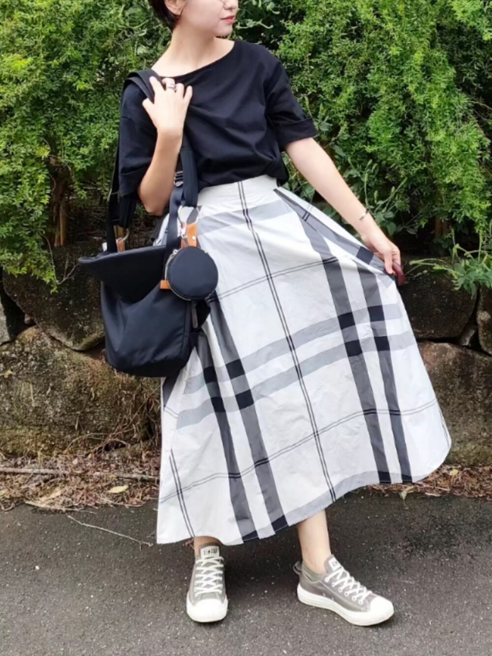 ブラック系のTシャツ/カットソー、ブラック系のバッグ、ブラウン系のスニーカーを着用したレディースの秋コーディネートの3枚目の写真