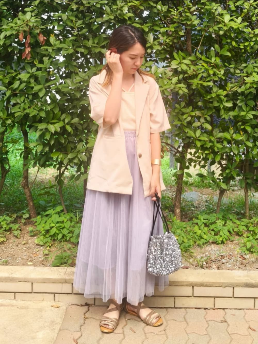 ホワイト系のキャミソール、ホワイト系のテーラードジャケット、グレー系のスカートを着用したレディースの夏コーディネートの3枚目の写真