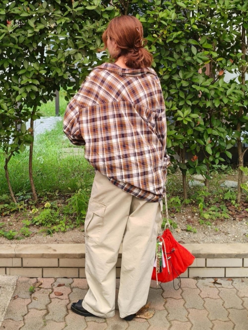 ベージュ系のカーゴパンツ、レッド系のシャツ/ブラウス、オレンジ系のショルダーバッグを着用したレディースの秋コーディネートの4枚目の写真