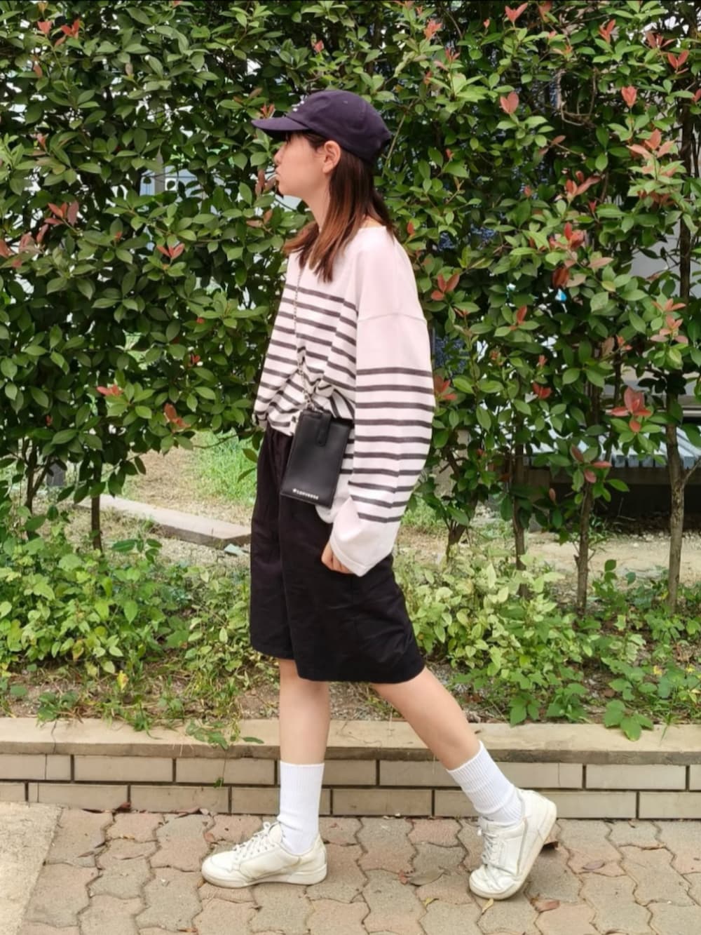 ホワイト系のTシャツ/カットソー、ブラック系のショルダーバッグ、ブラック系のその他パンツを着用したレディースの秋コーディネートの3枚目の写真