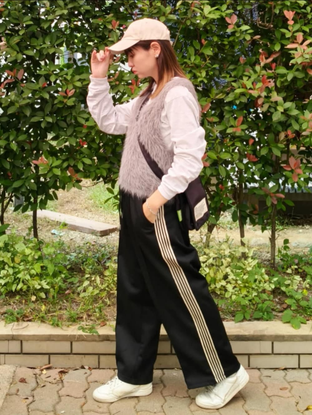 グレー系のTシャツ/カットソー、グレー系のベスト、ブラック系のショルダーバッグを着用したレディースの秋コーディネートの3枚目の写真