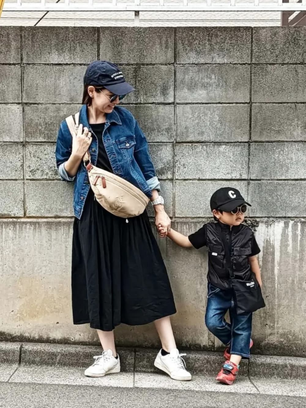 ブルー系のデニムジャケット、ベージュ系のショルダーバッグ、ホワイト系のスニーカーを着用したレディースの春コーディネートの2枚目の写真