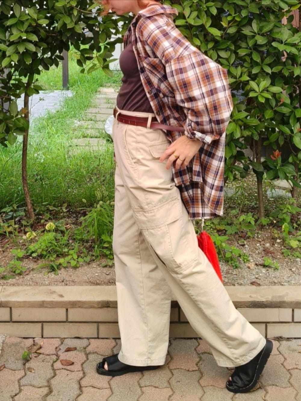 ベージュ系のカーゴパンツ、レッド系のシャツ/ブラウス、オレンジ系のショルダーバッグを着用したレディースの秋コーディネートの3枚目の写真